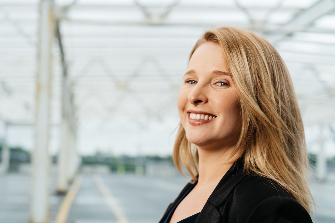 girl standing on bridge smiling at camera