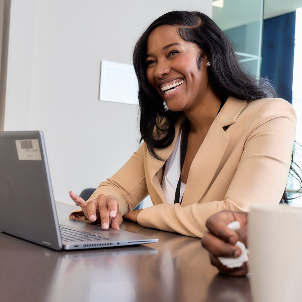 A person working on a laptop smiling 