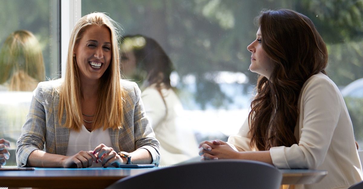 Two female coworkers sitting at a table