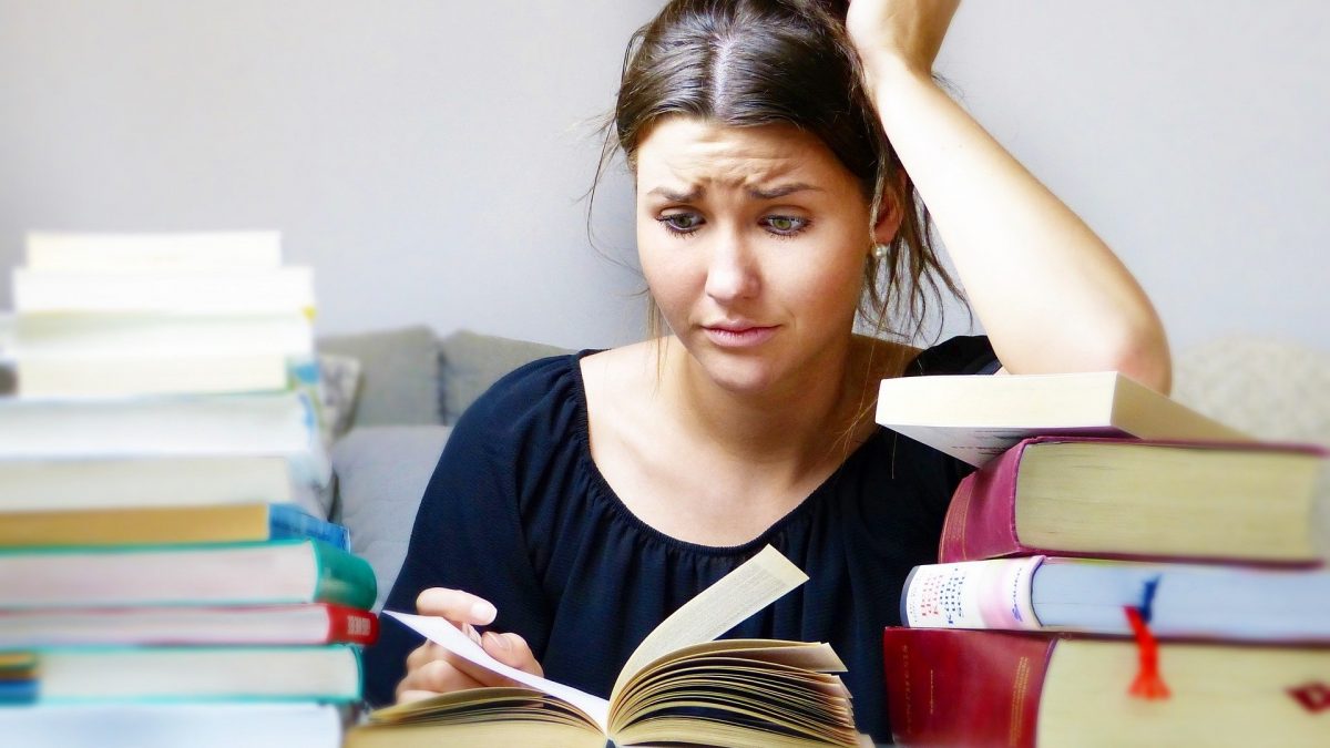 Stressed girl surrounded by books