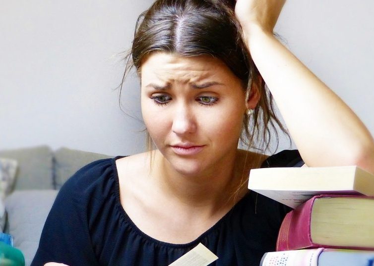 Stressed girl surrounded by books