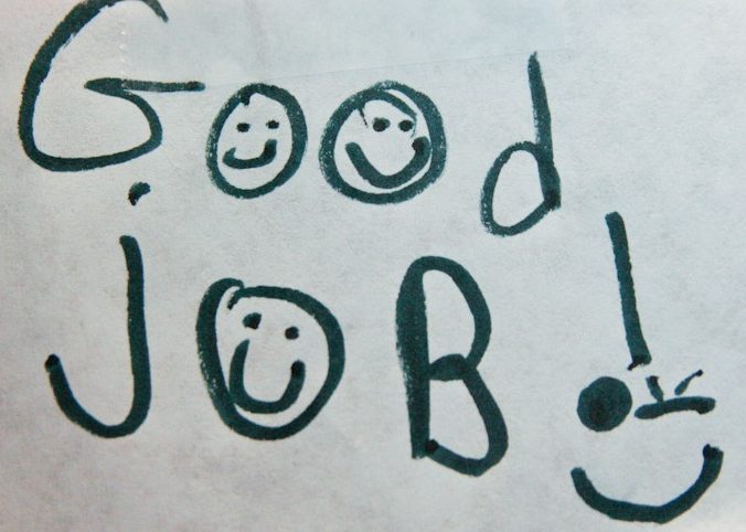 Piece of notebook paper that says "good job" with smiley faces
