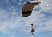 People about to land on the beach after skydiving
