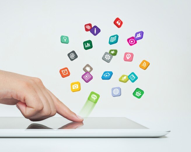 finger pressing an iPad and app icons are flying up
