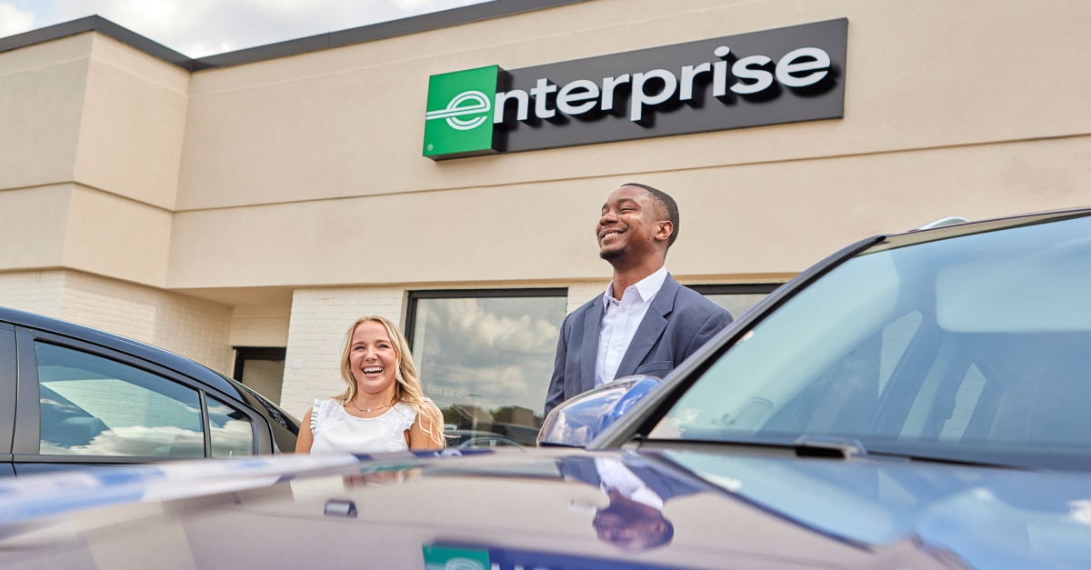 Selfie of female worker in front of Enterprise sign