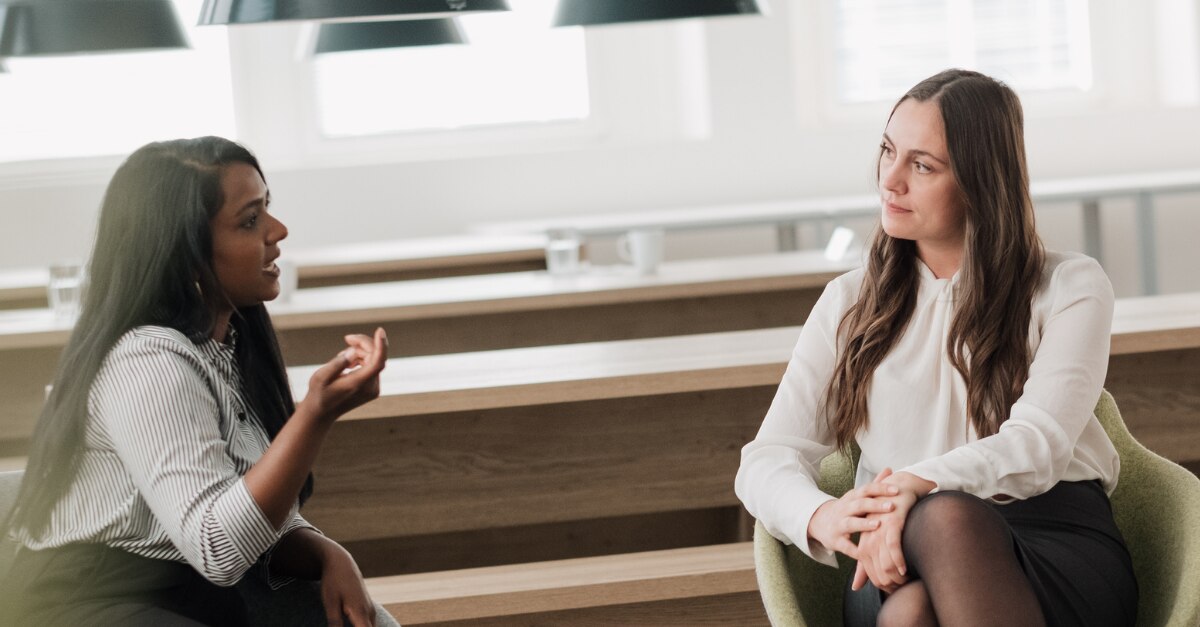 Two female coworkers talking