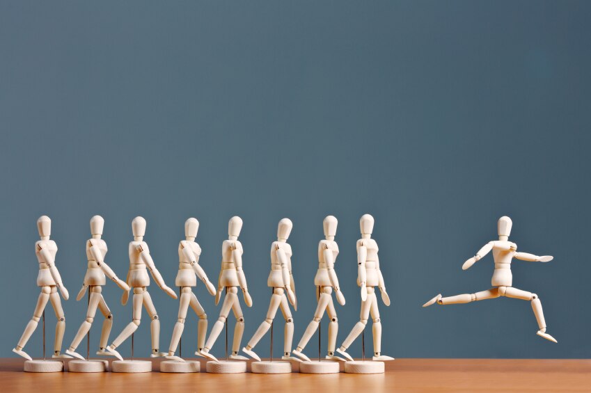 Wooden people figurines in progression from walking to leaping