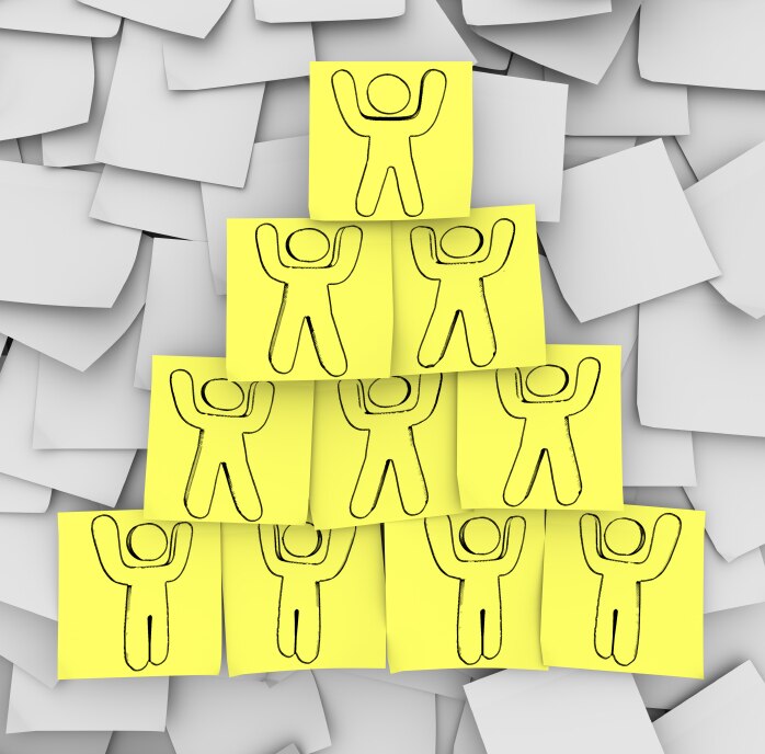 Yellow sticky notes with people drawn on them arranged in a pyramid