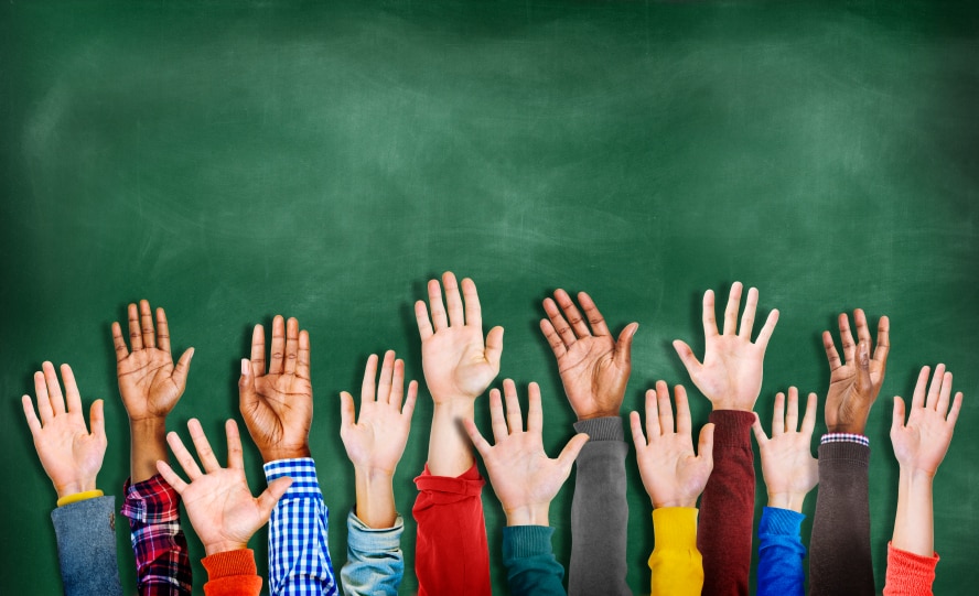 Hands raised in front of a chalk board background
