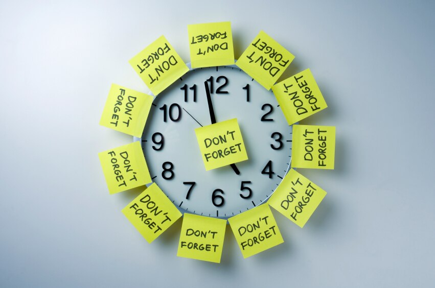 Clock covered in yellow sticky notes that say "Don't Forget"