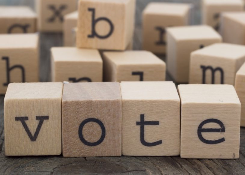 Alphabet blocks with some configured to spell "vote"