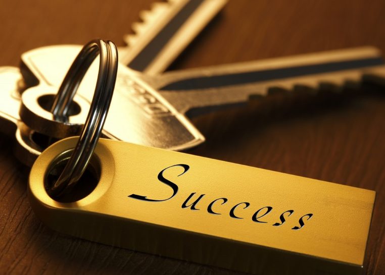 Gold keys with a gold keychain that says "success"