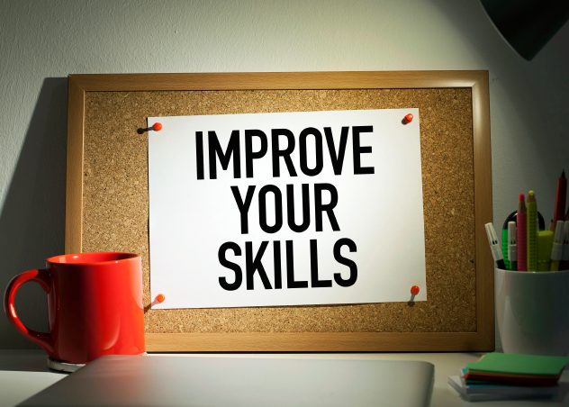 Cork board with paper that says "improve your skills"