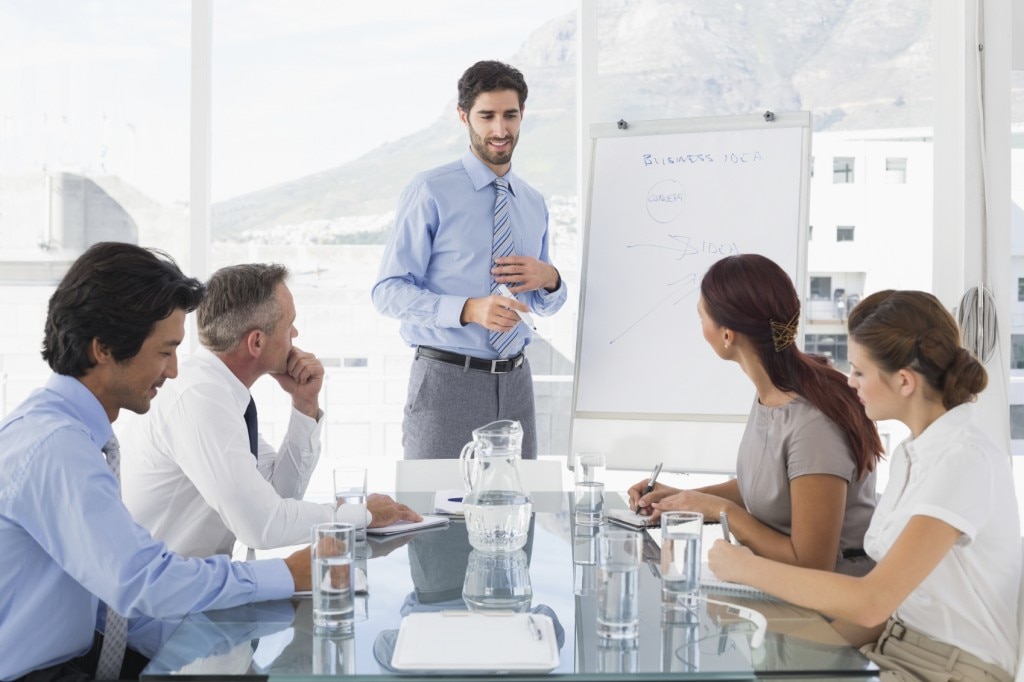 Business meeting with leader writing on white board