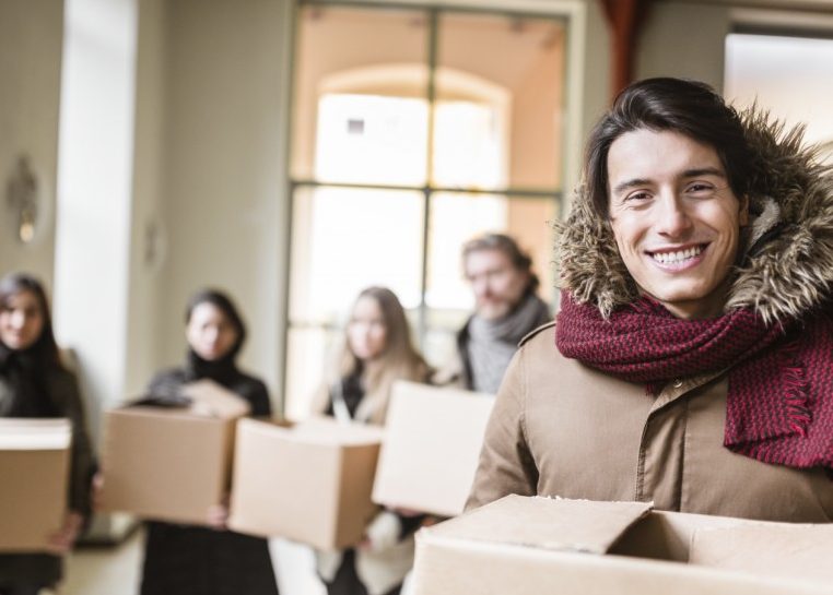People in coats carrying boxes
