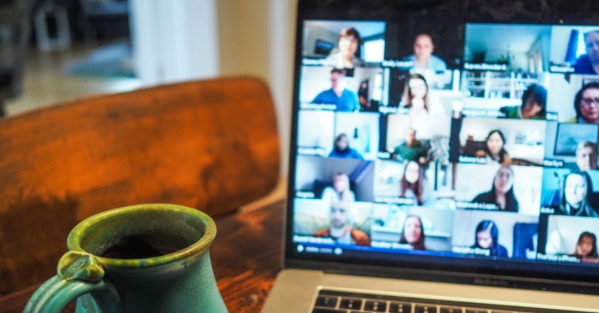 MacBook with Zoom meeting open and cup of coffee sitting on table