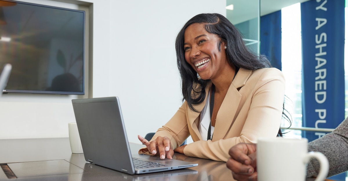 Female employee sitting in front of a blue wall