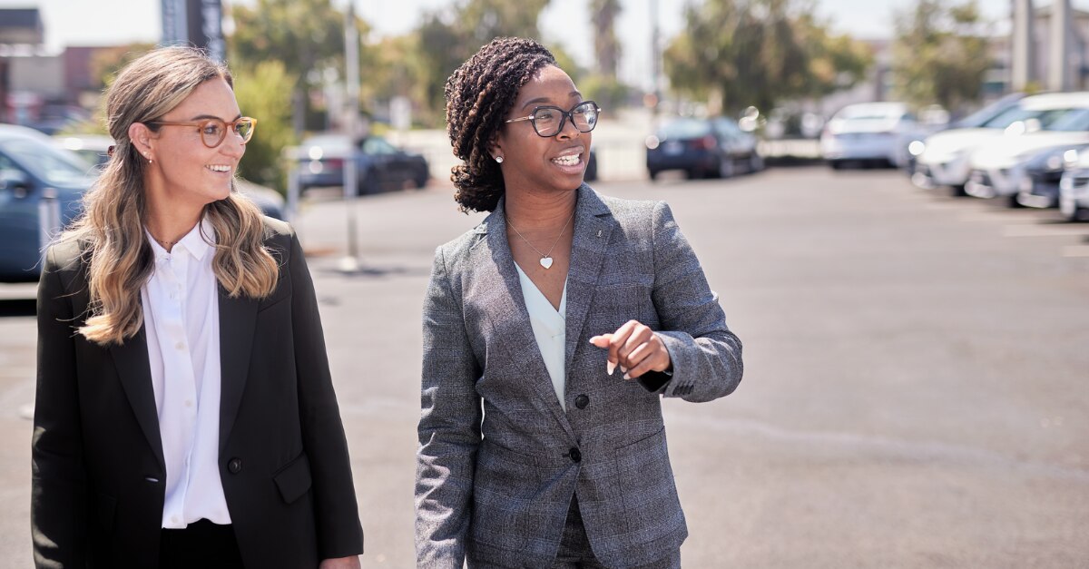 Two female employees walking in a parking lot