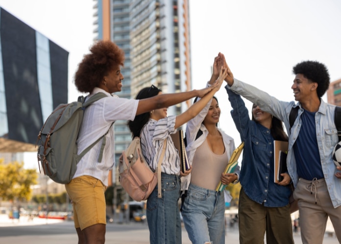 University students standing in a half circle high-fiving