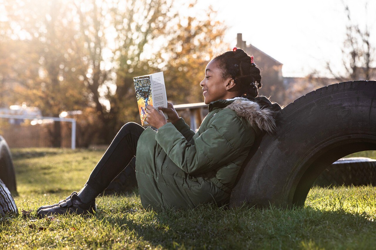 Child reading a book donated by the National Literacy Trust in conjunction with Enterprise Mobility as part of the Road Forward initiative. 