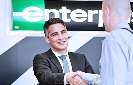 man in suit greets customer 